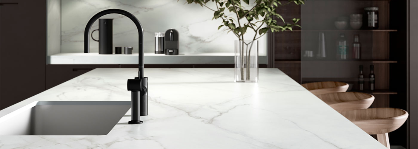 Helle Kücheninsel Barhocker und Spülenzeile an der Wandseite aus dem Material Dekton REM