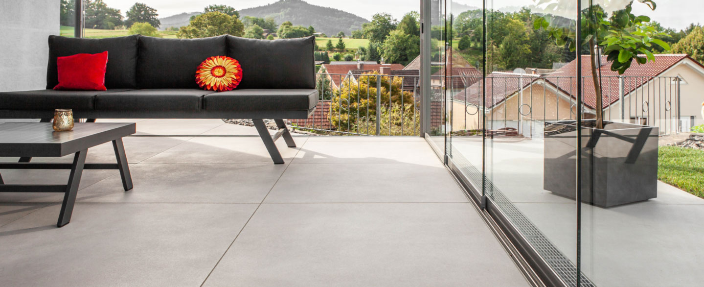 moderne Terrasse mit Verglasung und Terrassenplatten in Betonoptik