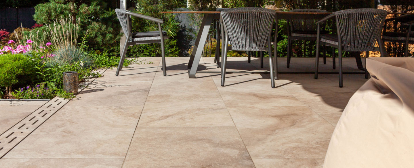 Terrassenmöbel auf Terrasse mit Keramik Terrassenplatten in beiger Natursteinoptik