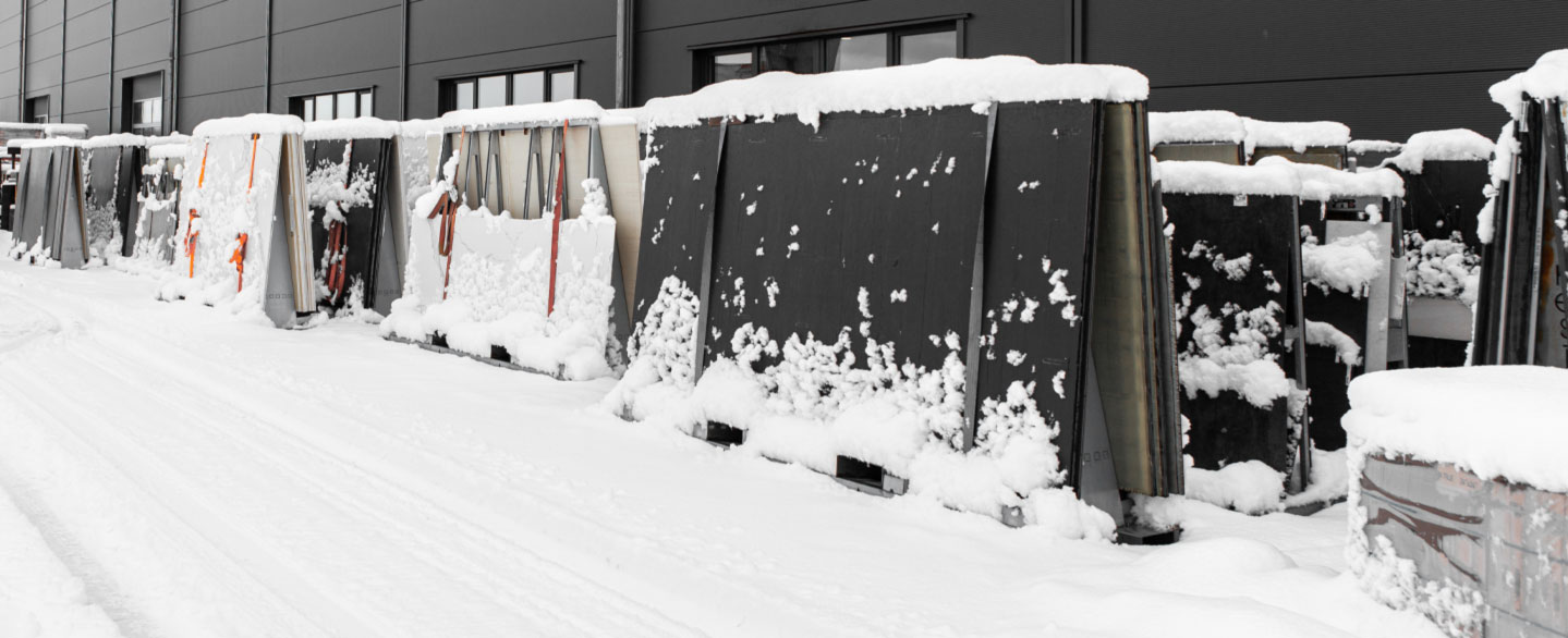 aufgereihte Rohplatten bei Dinger Stone unter einer Schneedecke
