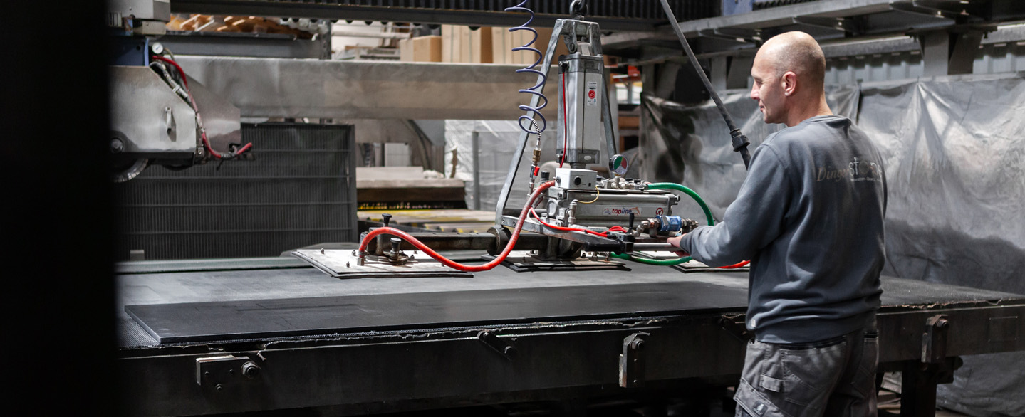 Produktionsmitarbeiter bedient Maschine in der Produktion um Arbeitsplatten anzuheben