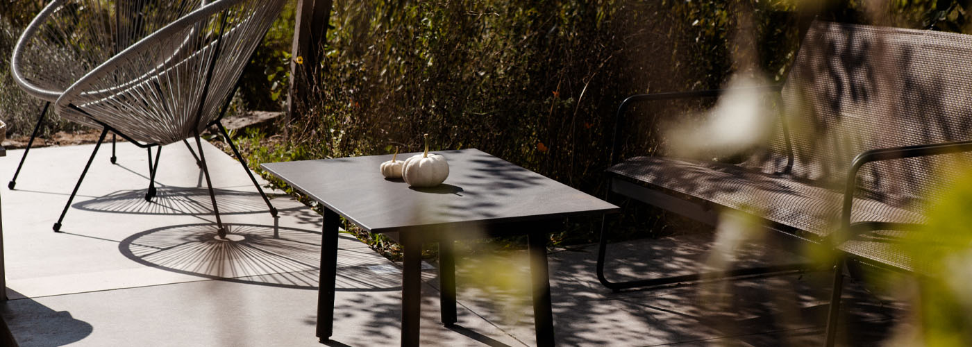 Outdoorausstellung mit Loungebereich bestehend aus Couchtisch mit Keramiktischplatte, Sessel und Outdoorsofa, herbstlich dekoriert