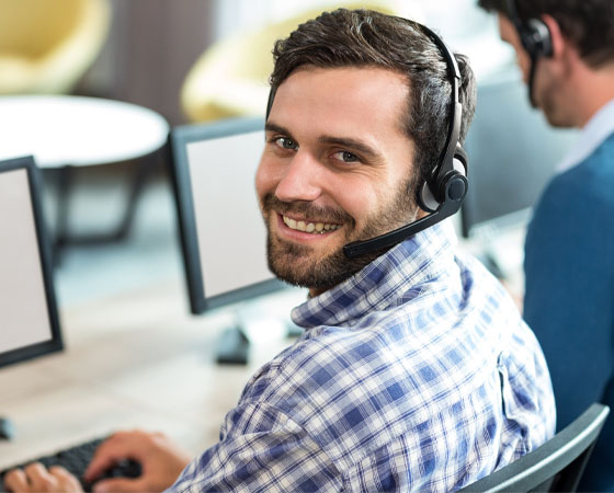 Mann der als Disponent für die Tourenplanung am Computer arbeitet mit Headset