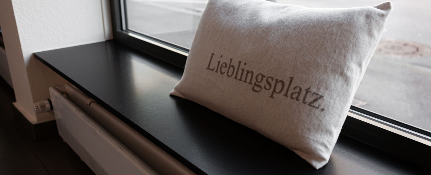 Schwarze Fensterbank aus Naturstein Nero Assoluto mit Kissen mit der Aufschrift "Lieblingsplatz"