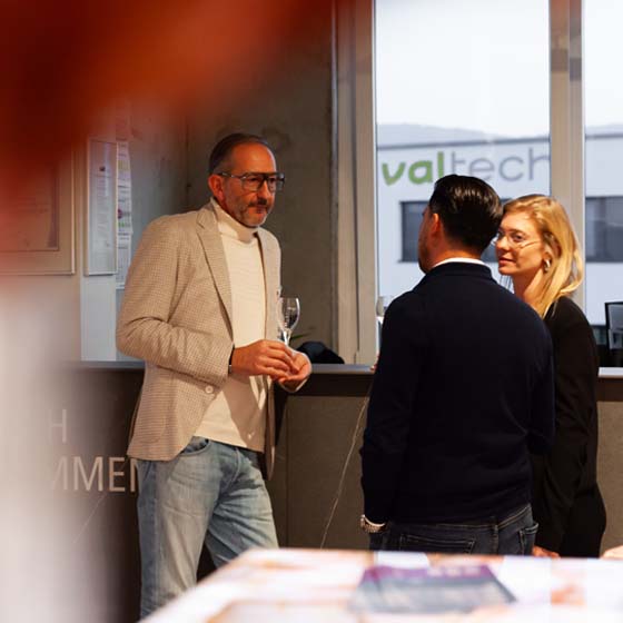 3personen-linda-stehen-vor-theke-rasterbild 3 Personen stehen an einer Theke und unterhalten sich.