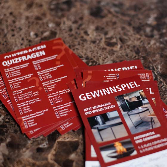 gewinnspiel-rasterbild Quizfragen (Gewinnspiel) Zettel liegen auf Steinplatte.