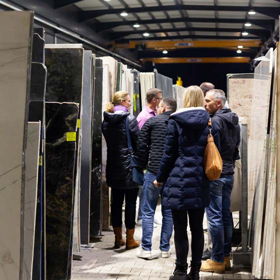 lagerbesichtigung-rasterbild Mehrere Personen schauen sich das Steinlager an.