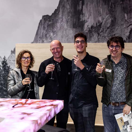 michelle-mit-kunden-neuheitengalerie-rasterbild Gruppenfoto mit Weingläser in der Hand.