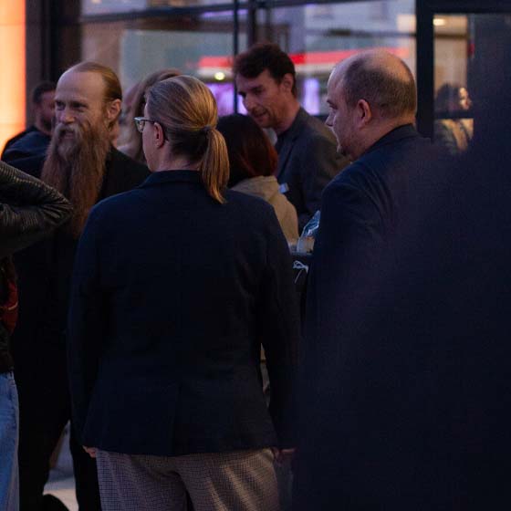 raphael-simeon-draußen-unterhaltung-kunden-rasterbild Raphael und Simeon Dinger stehen mit Kunden vor dem Eingang