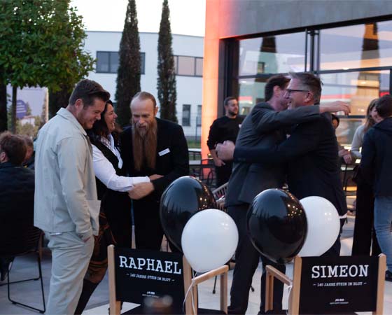 Kundenevent mit Umarmungen, Glückwünschen und Übergabe von Geschenken