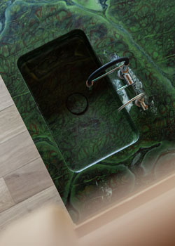 Grüne Kuecheninsel aus Naturstein Samba Moss mit materialgleicher Spüle WaterStone Mono