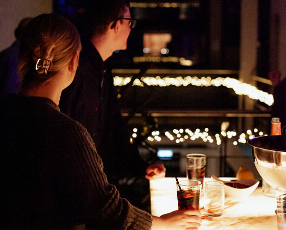 vorschau-firmenfeier-neujahrsfeier-weihnachtsfeier-getraenke-bokeh mitarbeitende haben drinks in der hand. gemütliche atmosphäre mit bokehlicht