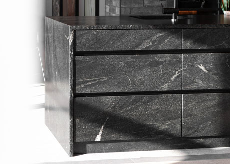 kuechenmoebelfront-polarblack-naturstein-kuechenblock-schubladenfront Küchenblock eingefasst in Naturstein Polar Black. Schubladenfronten materialgleich