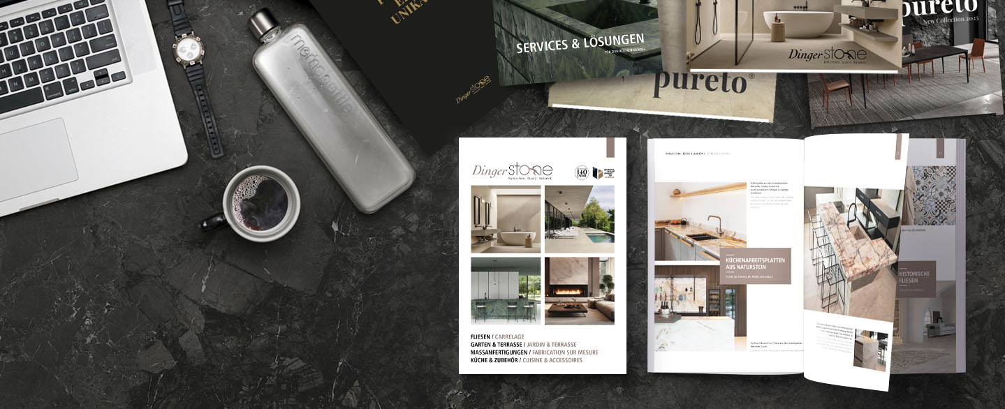 downloads-flatlay-broschueren-magazine-image-tables-schreibtisch Flatlay von oben: Schwarzer Steintisch mit teilweise aufgeschlagenen Dinger Stone Broschüren, Laptop, Kaffeetasse und Parfum