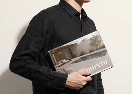 pureto-outdoor-ceramic-broschuere-mann-hemd-cover-magazin Mann in schwarzem Hemd hält Magazin unterm Arm