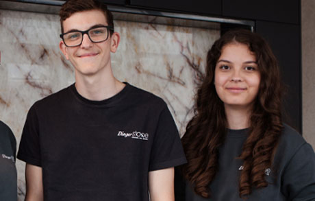 auszubildende-dingerstone-gruppenfoto-azubis2026 Auszubildende Julian und Andra-Denisa vor Steinrückwand