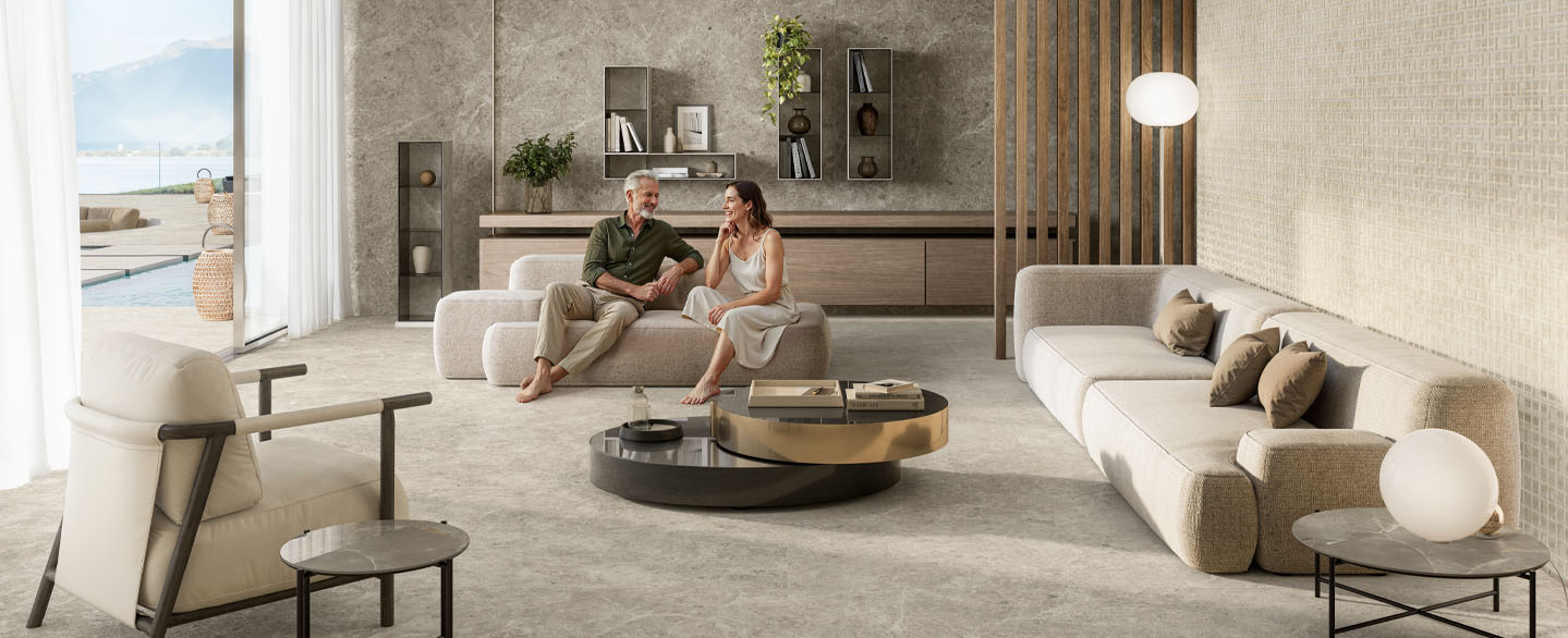 wohnzimmer-minimal-interior-ceramicdesign-sofa-people Mann und Frau sitzen auf der Couch eines hellen modernen Wohnzimmers